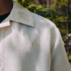 Close up of collared shirt and embroidery details on model