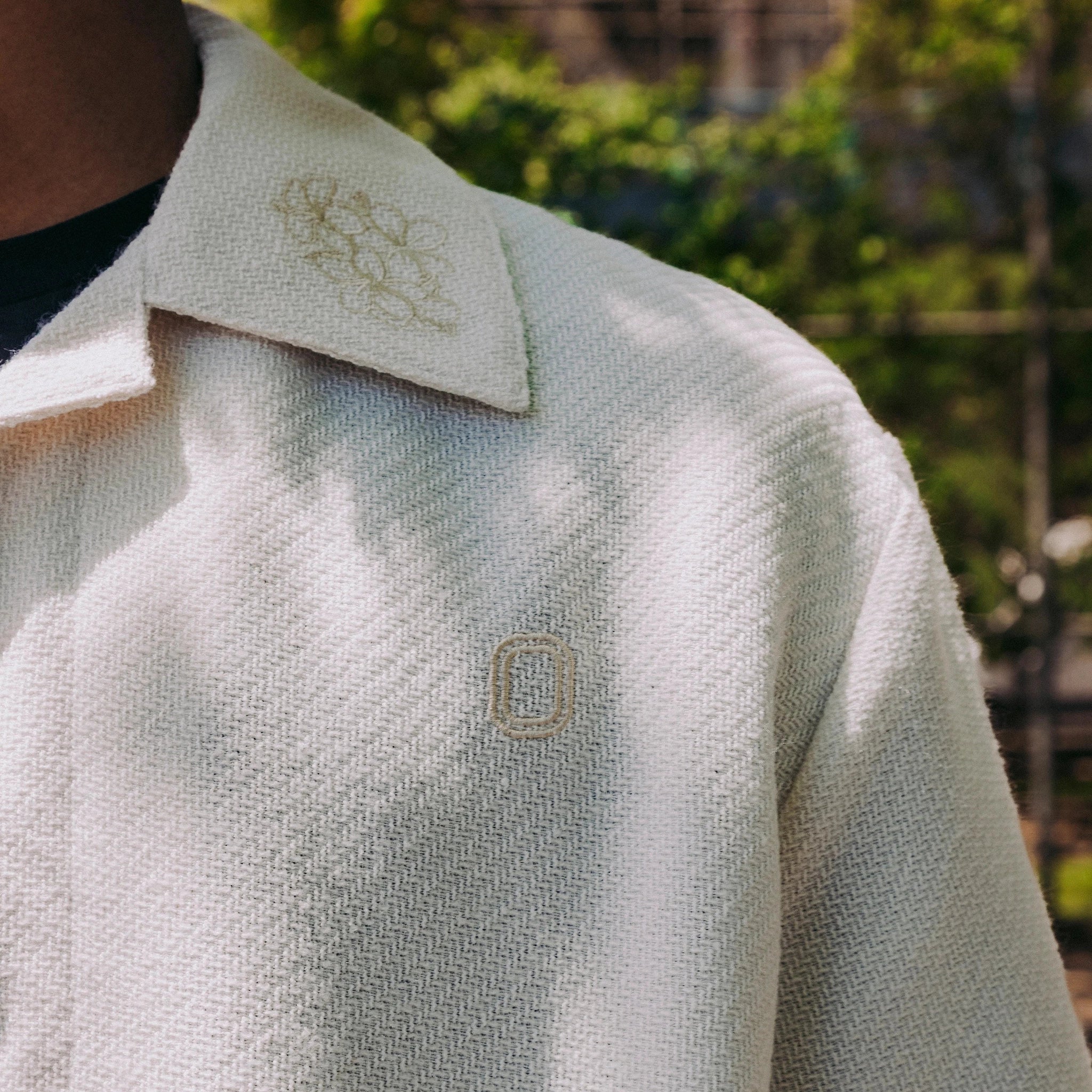Close up of collared shirt and embroidery details on model