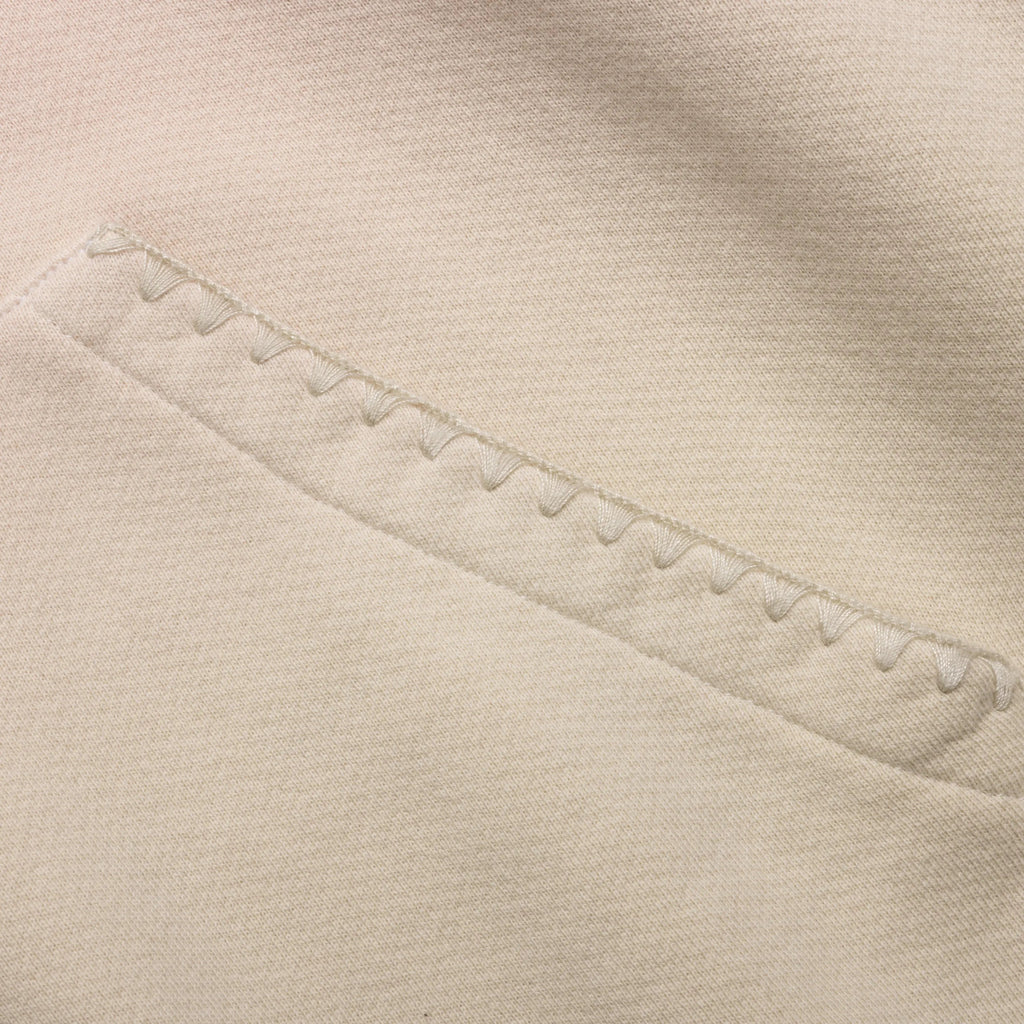 Close-up of beige fabric with a visible seam