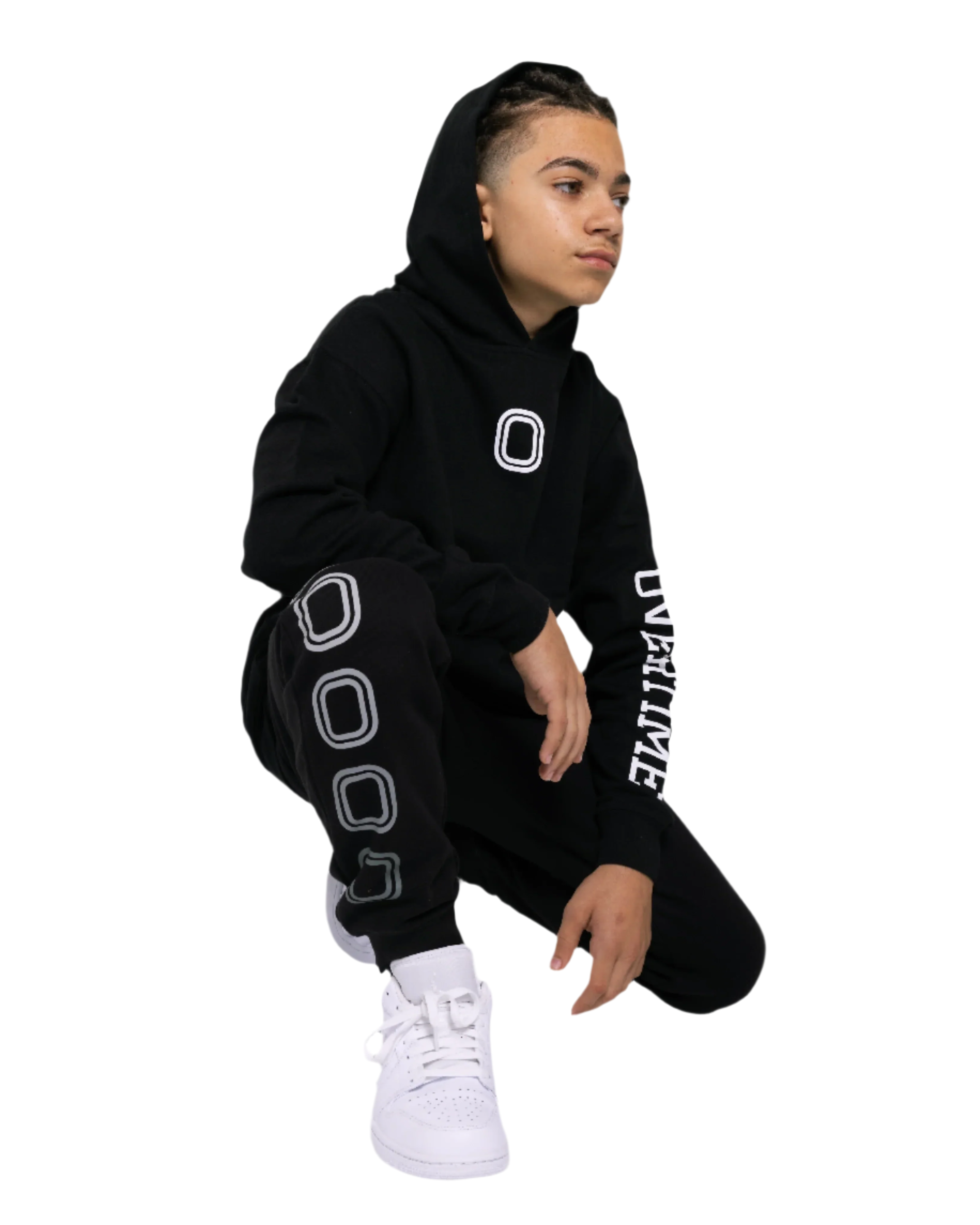 A kid wearing a black hoodie with a 'O' logo print on the chest and 'OVERTIME' print on the sleeve.