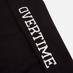 A close-up of 'OVERTIME' print on the sleeve.