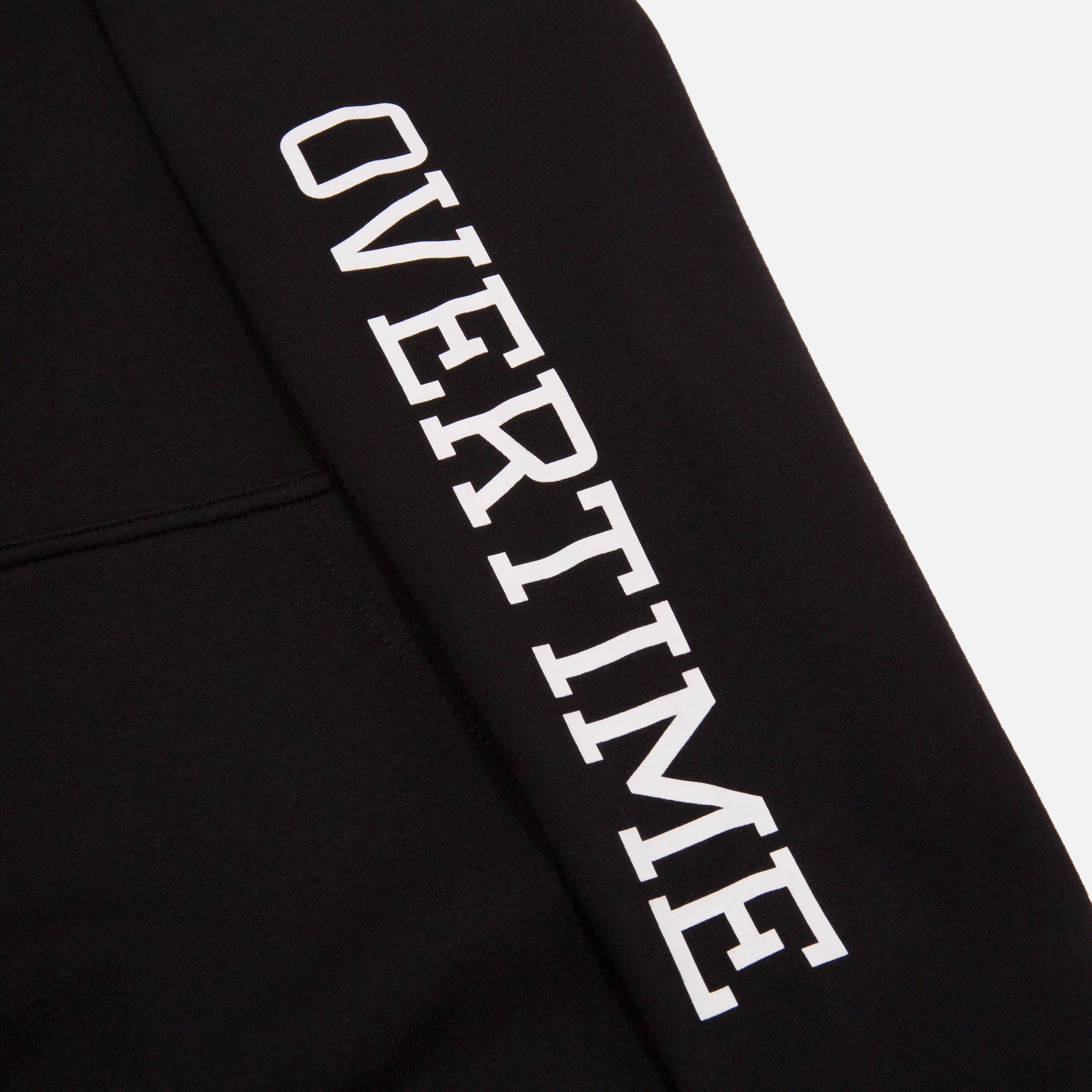 A close-up of 'OVERTIME' print on the sleeve.
