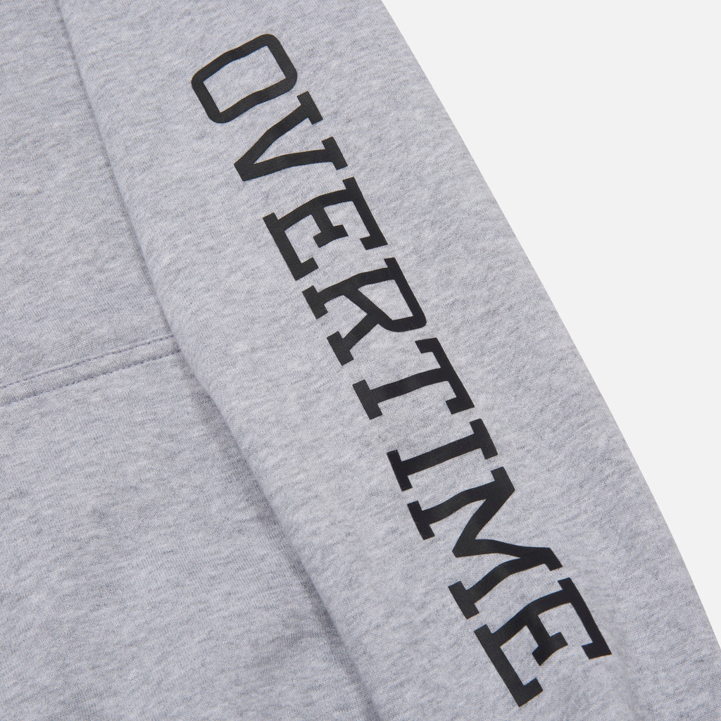 A close-up of 'OVERTIME' print on the sleeve.