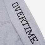 A close-up of 'OVERTIME' print on the sleeve.
