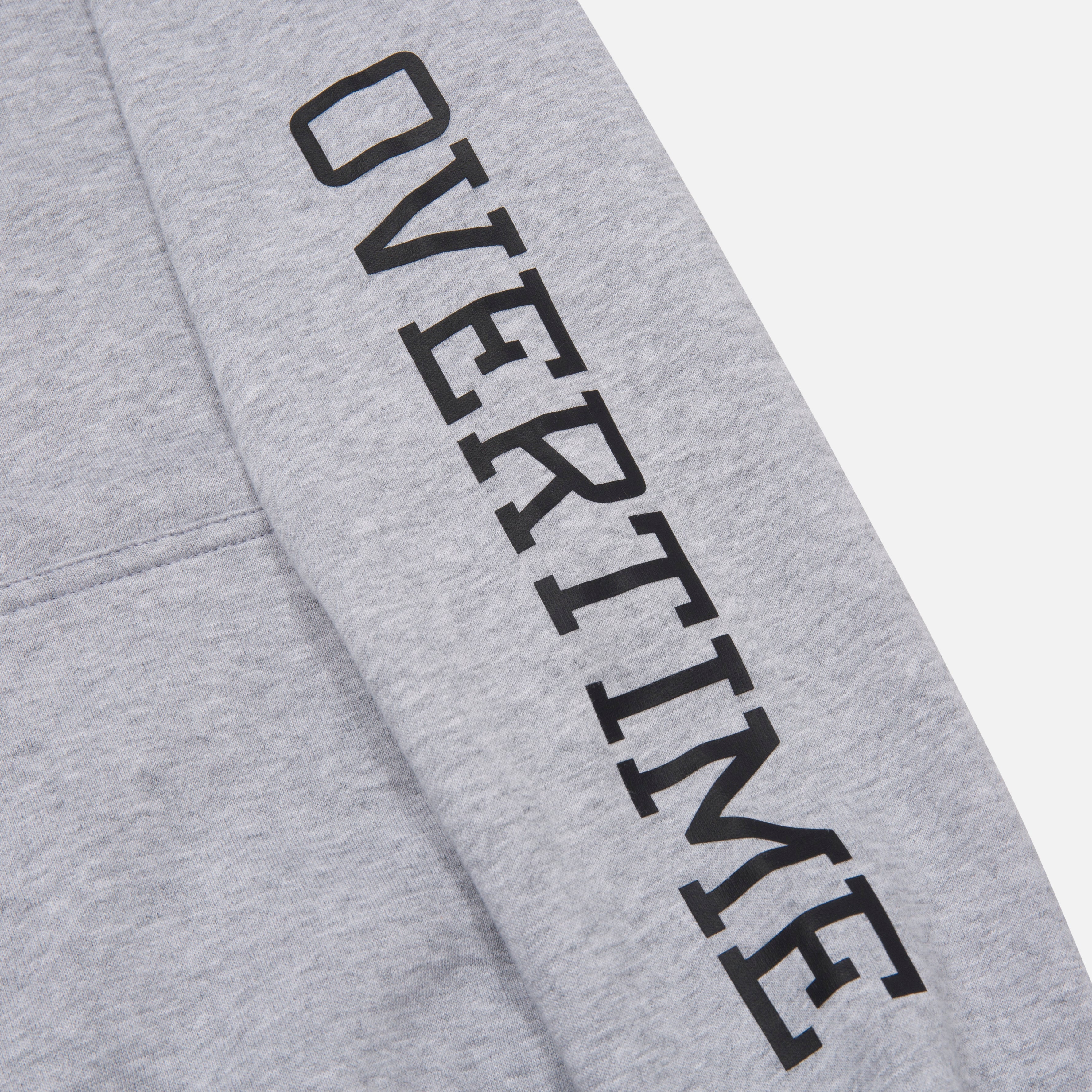 A close-up of 'OVERTIME' print on the sleeve.