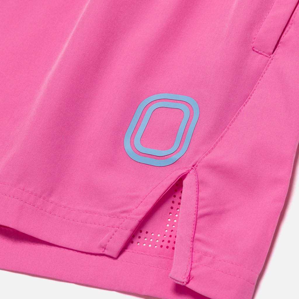 Close-up of pink shorts with a blue logo on a white background