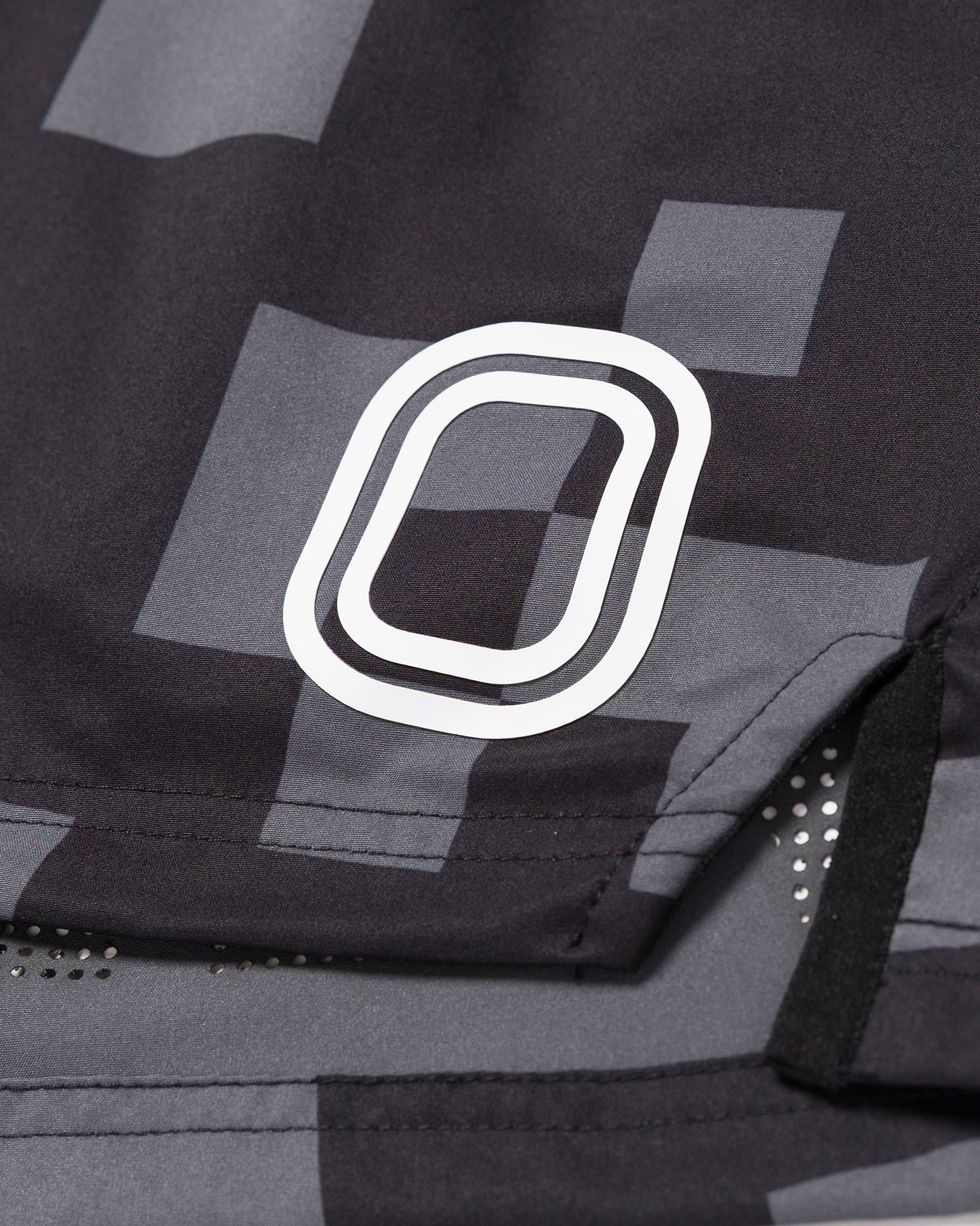Close-up of a black and gray patterned shorts with white "O" Logo