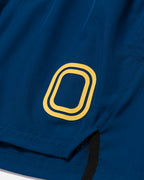 Close-up of a blue shorts with a yellow "O" logo