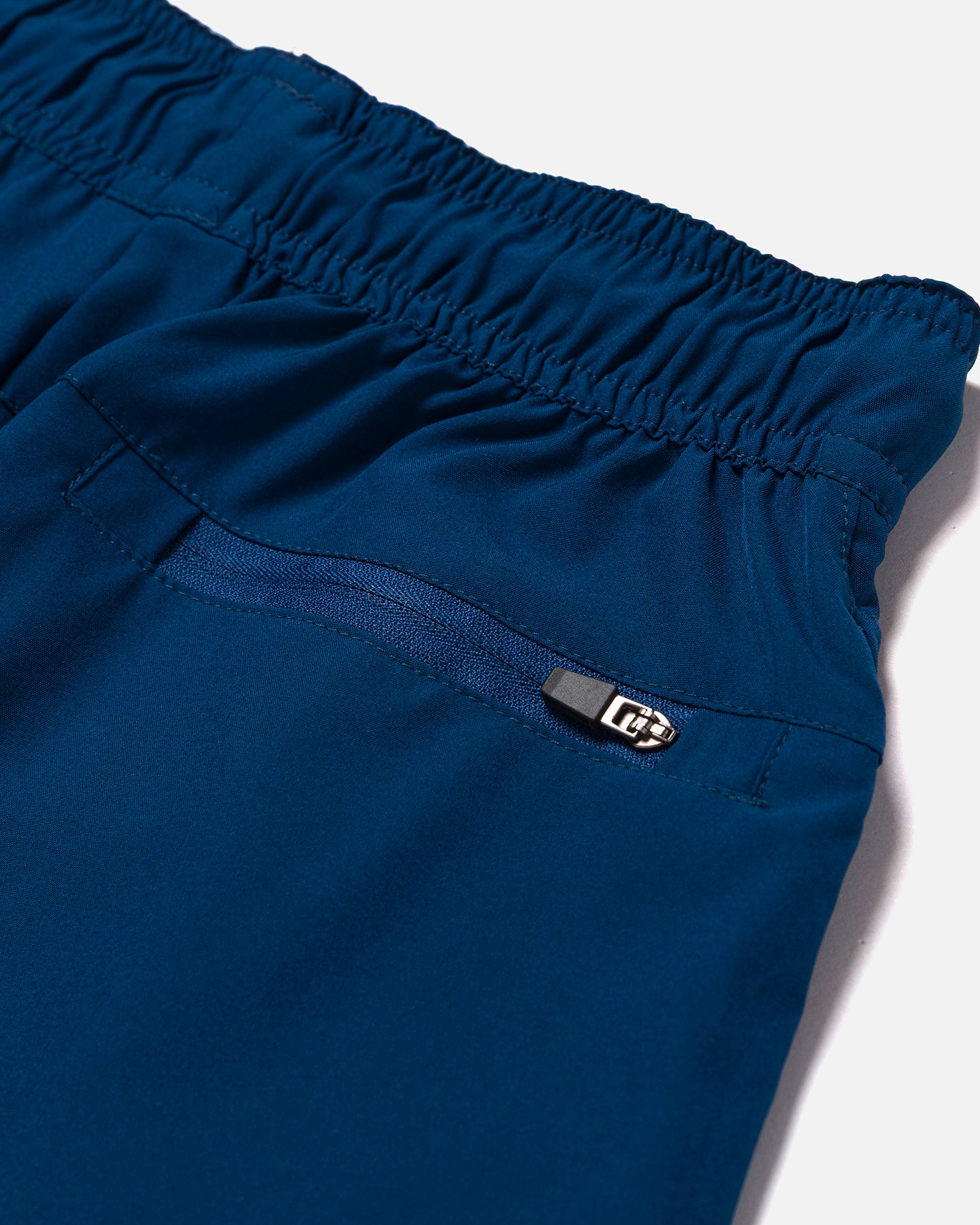 Close-up of blue shorts with a back zipper pocket