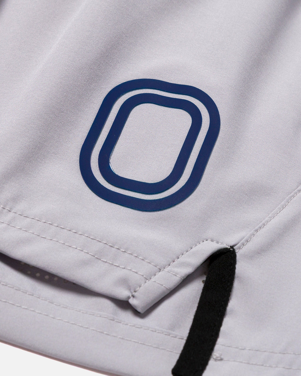 Close-up of a grey garment with a blue "O" logo