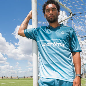 Person wearing a blue "OVERTIME" soccer jersey